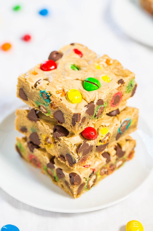 stack of three m&m cookie bars on a white plate