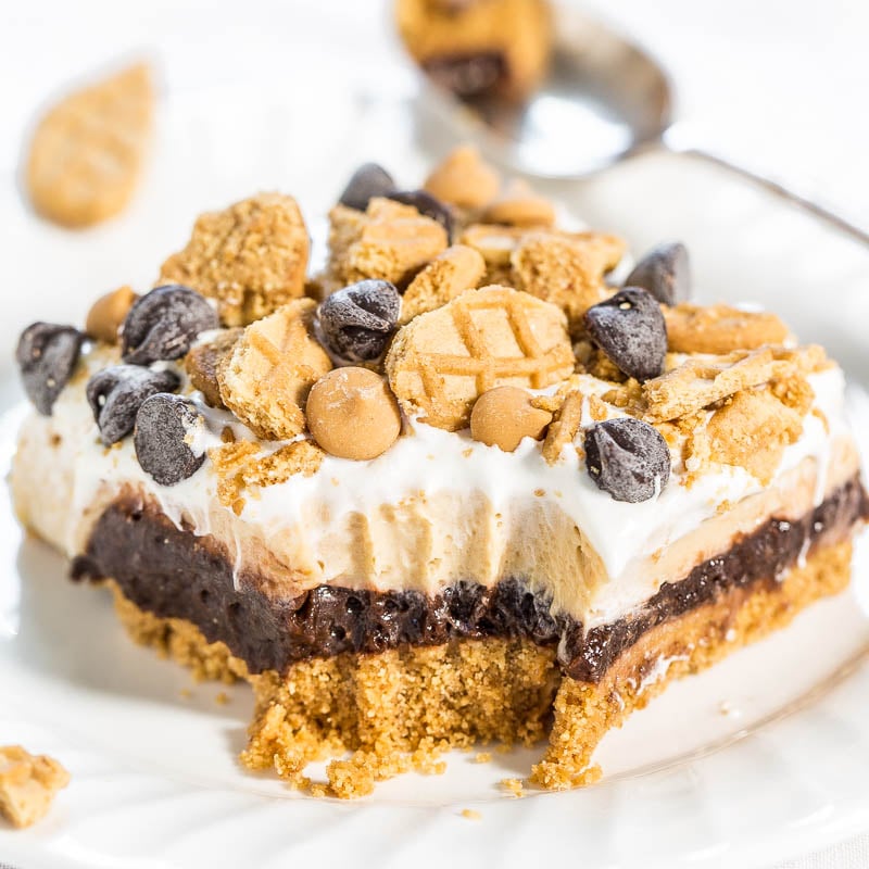 A close-up of a layered dessert with cookie crumbles and chocolate chips on top.