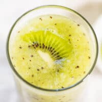 Glass of kiwi smoothie topped with a kiwi slice.