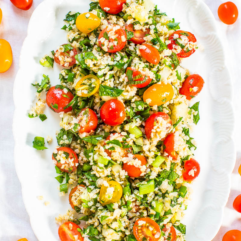 A plate of tabbouleh salad with cherry tomatoes, chopped parsley, and bulgur wheat.