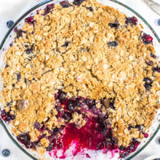 Blueberry Crisp in a pan with a scoop missing.