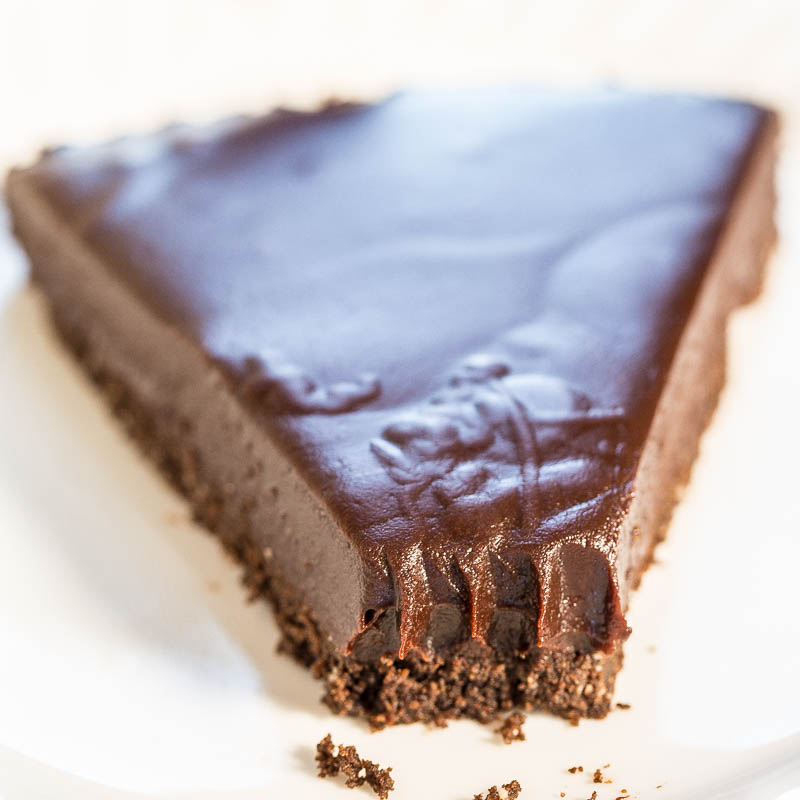 A slice of chocolate tart on a white plate.