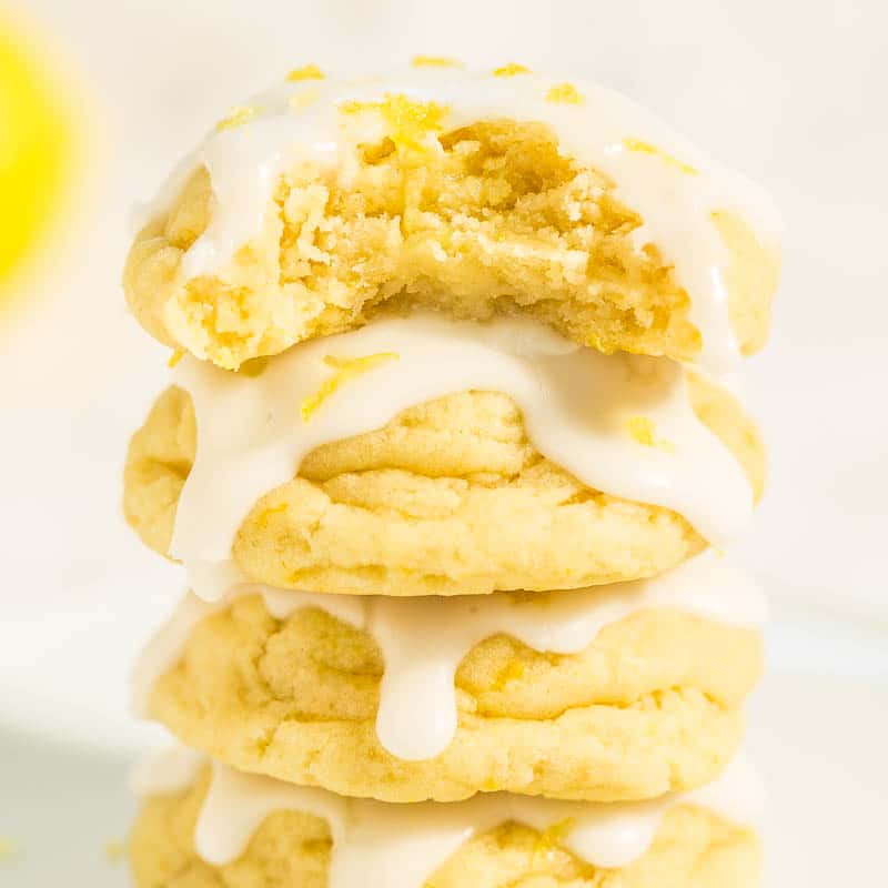 A stack of lemon cookies with white icing drizzle.