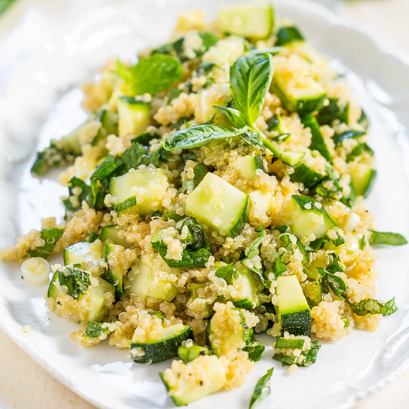 A plate of quinoa salad with zucchini and fresh herbs.