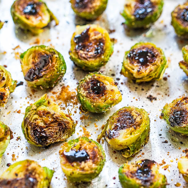 Roasted brussels sprouts with browning and caramelization on parchment paper.