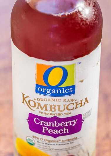 A close-up of a bottle of organics kombucha with cranberry peach flavor.