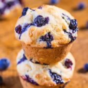 Blueberry muffin stacked on top of another, showcasing its baked berries and golden-brown crust.