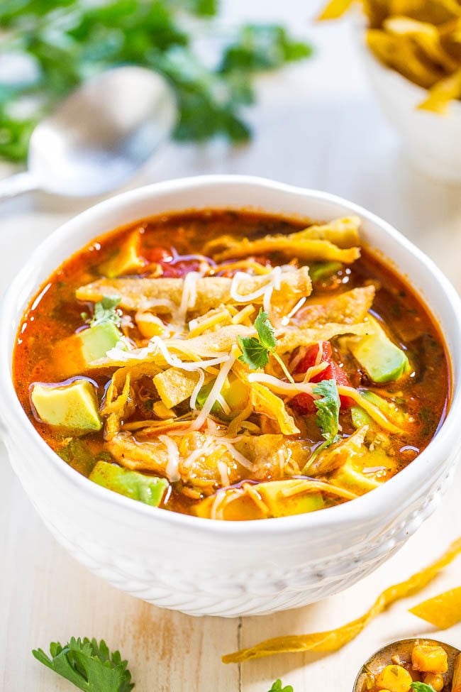 A white bowl of quick chicken tortilla soup. 