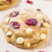 White chocolate chip and cranberry cookie on a wooden surface.