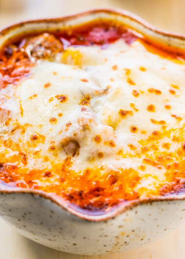 Baked lasagna with melted cheese in a ceramic dish.