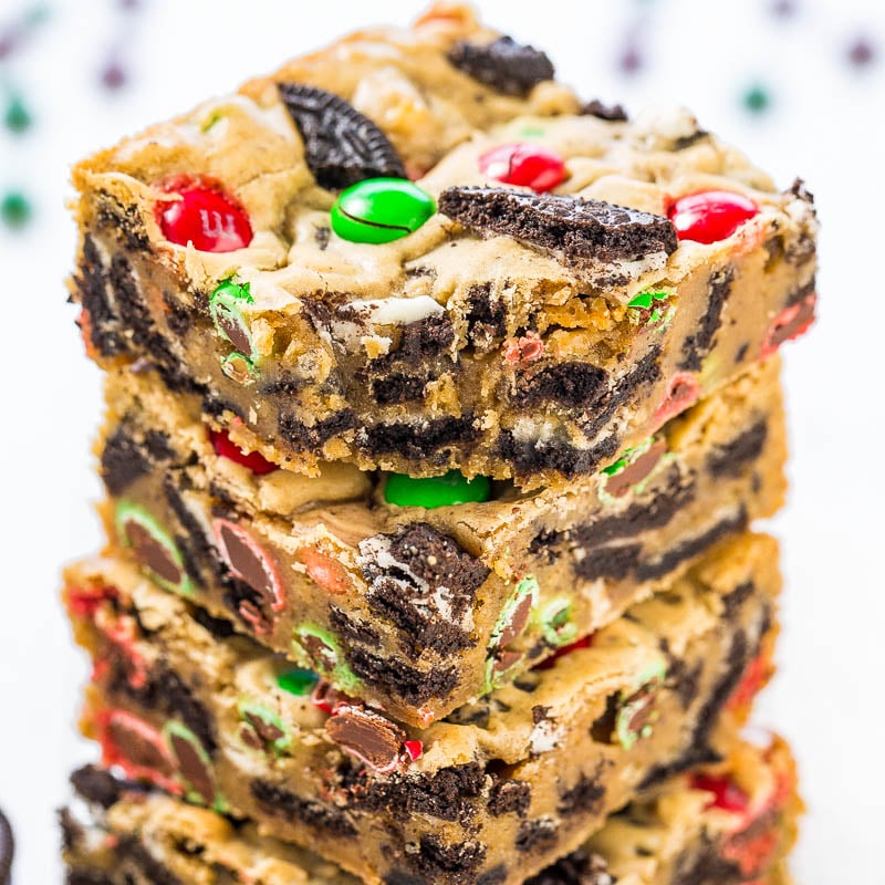 A stack of festive cookie bars with colorful candies and cookie pieces.