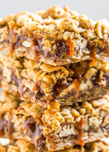A stack of chewy oatmeal bars with drizzled caramel.