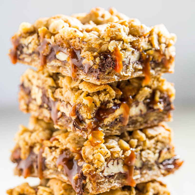 A stack of chewy oatmeal bars with drizzled caramel.