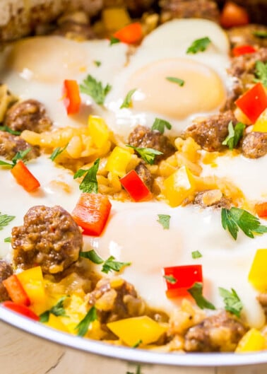 A skillet with sausage, bell peppers, corn, and topped with baked eggs.