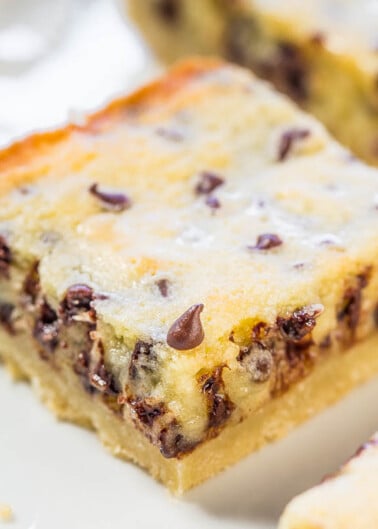 A close-up of a chocolate chip cheesecake bar on a plate.