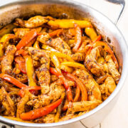 Stir-fried chicken with bell peppers in a skillet.