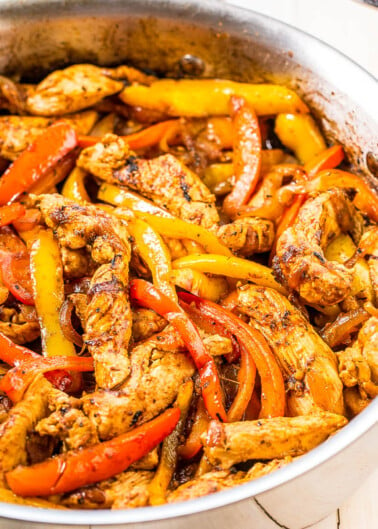 Stir-fried chicken with bell peppers in a skillet.