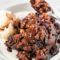 A serving of chocolate lava cake with a scoop of vanilla ice cream on a plate.