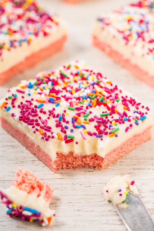 Strawberry Cookie Bars with Vanilla Cream Cheese Frosting on a wooden surface