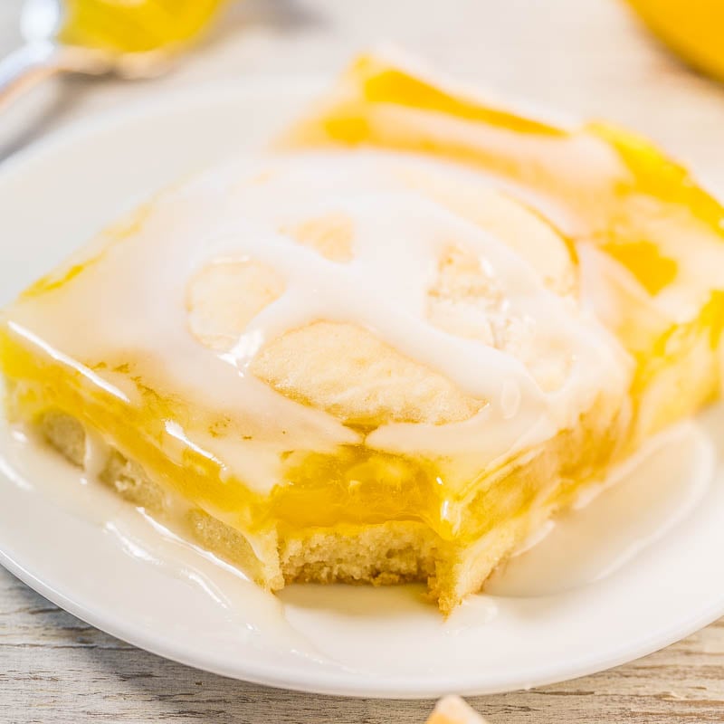 A slice of lemon cake with icing on a white plate.