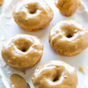 Glazed doughnuts on a white plate.