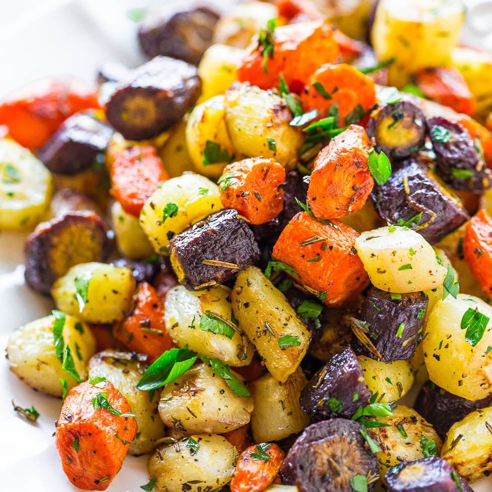 A colorful dish of roasted potatoes with a mix of herbs.
