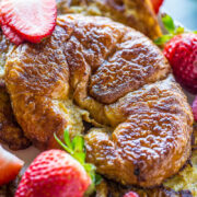 Golden-brown french toast garnished with fresh strawberries.