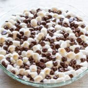 A glass dish filled with mini marshmallows and chocolate chips.
