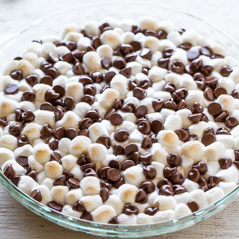 A glass dish filled with mini marshmallows and chocolate chips.