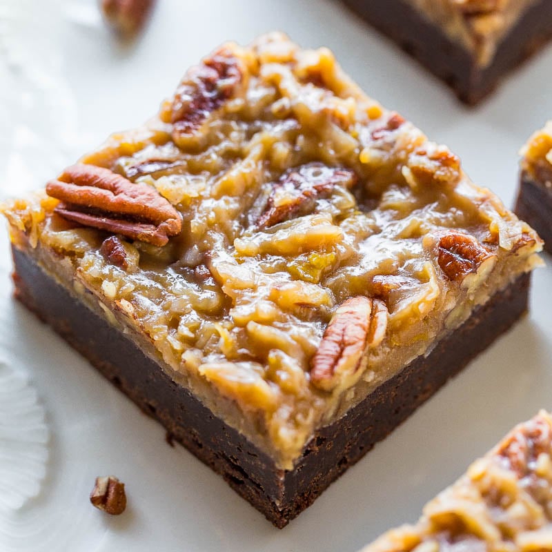 A single pecan pie brownie on a white plate, featuring a fudgy base topped with gooey pecan pie filling.