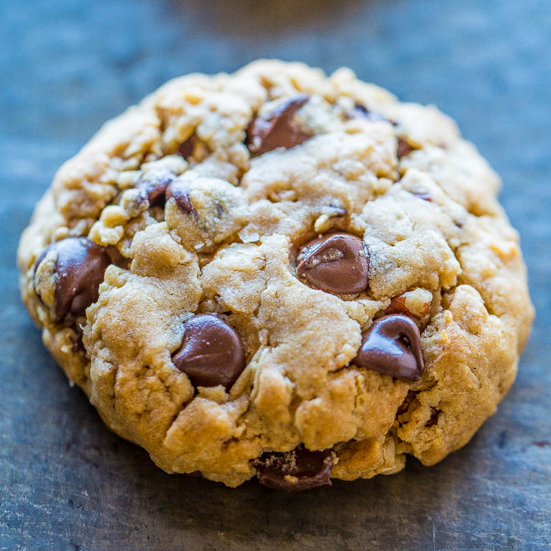 A close-up photo of a chocolate chip cookie on a dark surface.