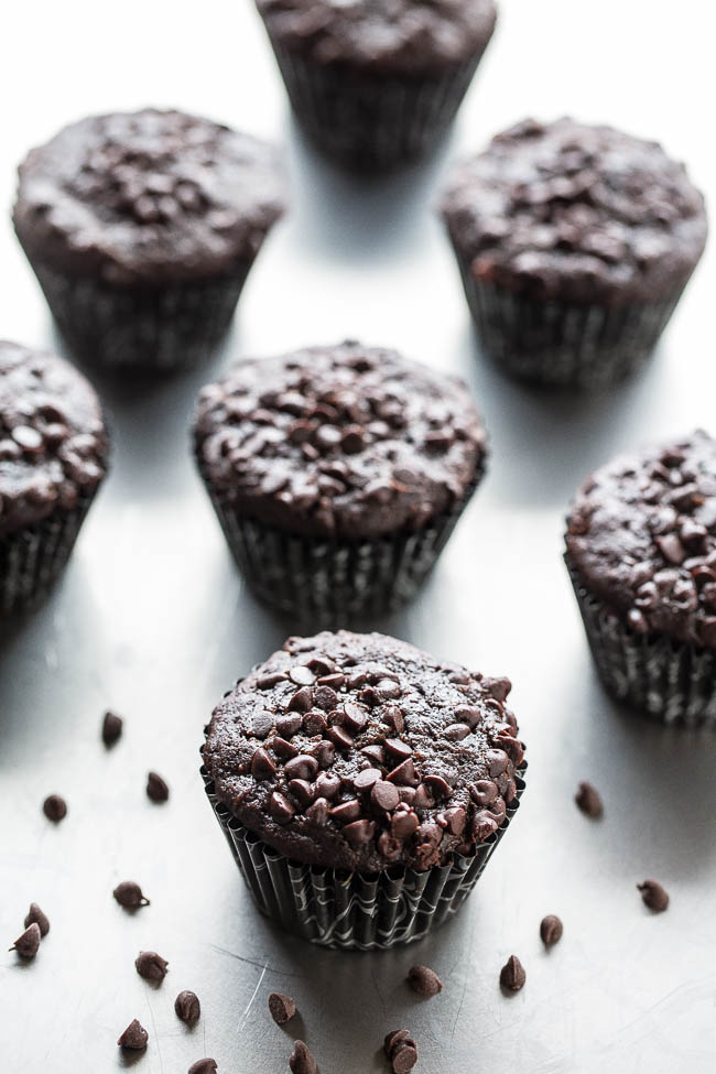 Chocolate Zucchini Muffins on countertop with mini chocolate chips
