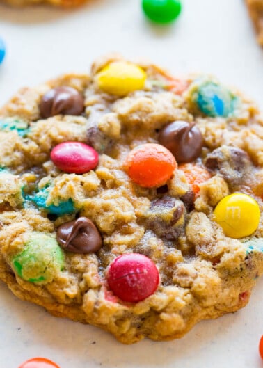 A homemade cookie with colorful candy pieces baked into it.
