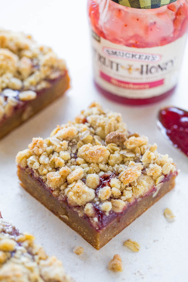 Peanut Butter and Jelly Crumble Bars - Soft and chewy PEANUT BUTTERY bars topped with strawberry jelly and a crispy oatmeal crumble topping!! Easy, no-mixer recipe that'll be your new FAVORITE way to eat PB&J!!