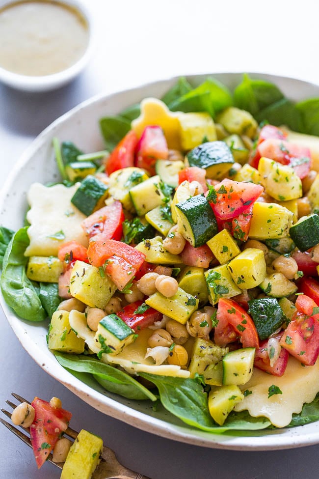 Summer Ravioli Salad — Crisp-tender zucchini, yellow squash, tomatoes, and chickpeas over spinach with cheesy ravioli and a dijon vinaigrette!! A HEALTHY summer pasta salad that takes advantage of fresh produce!!