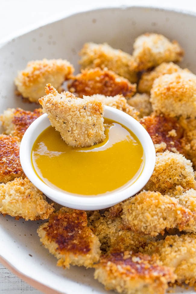 Bowl of Baked Chicken Nuggets with Honey Mustard  with one being dipped into sauce