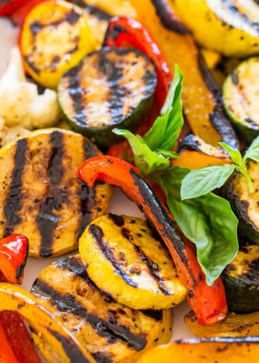 Grilled mixed vegetables seasoned and garnished with basil leaves.