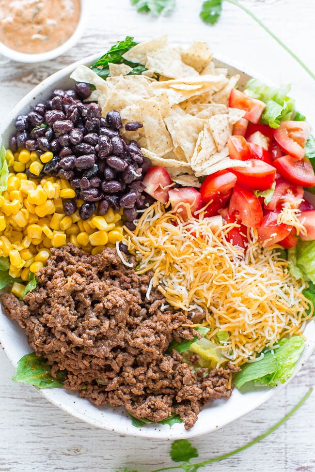 Loaded Beef Taco Salad with Creamy Lime Cilantro Dressing - Loaded with your favorite taco fixings, minus the shells, to keep things healthier without sacrificing any FLAVOR!! The dressing is easy, creamy and IRRESISTIBLE!! 