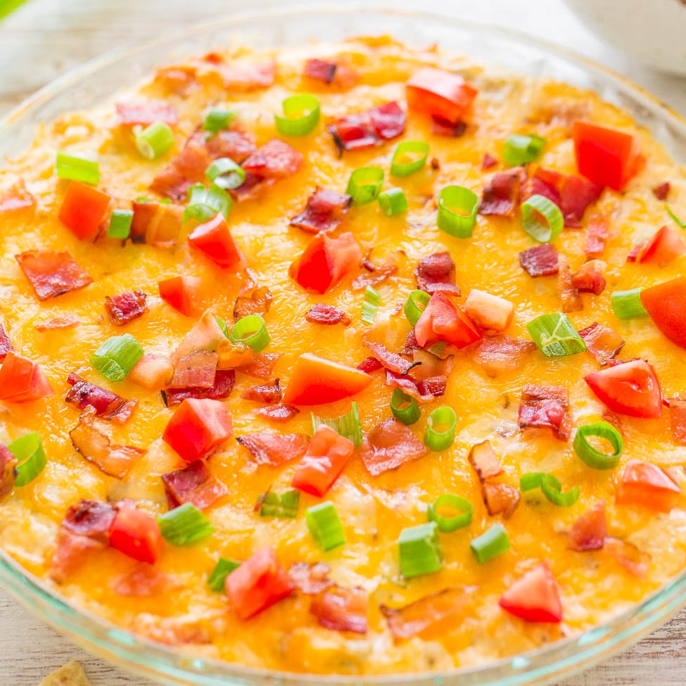 Cheese and bacon topped dip garnished with green onions and diced tomatoes.