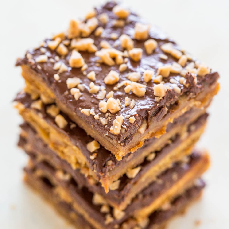 A stack of chocolate caramel bars sprinkled with chopped nuts.