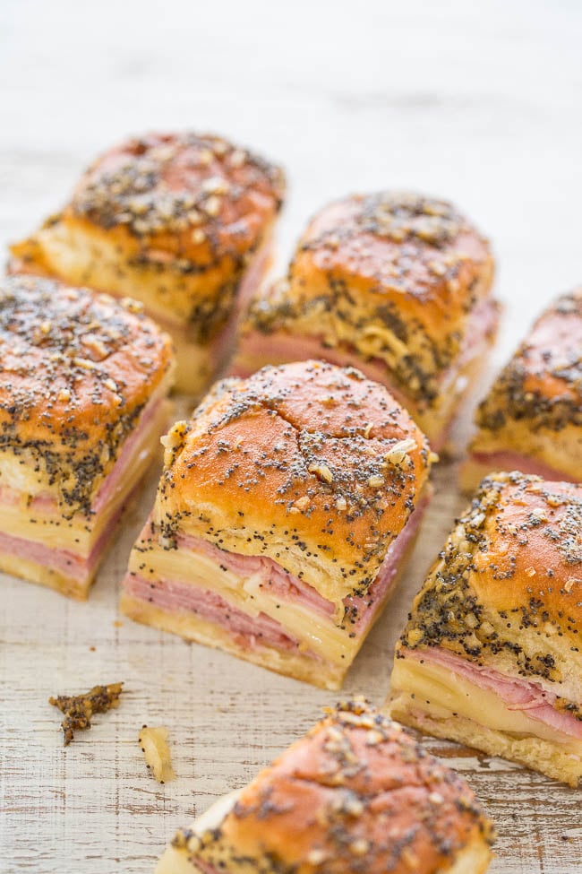 Six ham and cheese sliders topped with poppyseeds. 