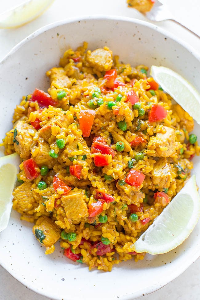 Easy Chicken Paella - If you're never made paella before, here's how with this EASY recipe ready in 45 minutes!! Juicy chicken and tender rice with onions, peppers, tomatoes, and more! So much FLAVOR in every bite!!