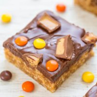 Homemade candy bar-inspired dessert square with toppings on a wooden surface.
