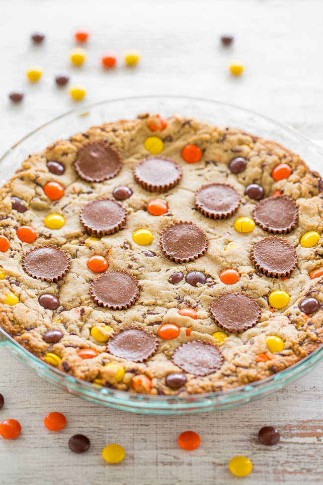 Loaded Peanut Butter Cookie Pie - Peanut butter is used 3 WAYS: In the dough, with peanut butter cups, and Reese's Pieces!! EASY, no mixer, super soft center with chewy edges, and tastes AMAZING!!