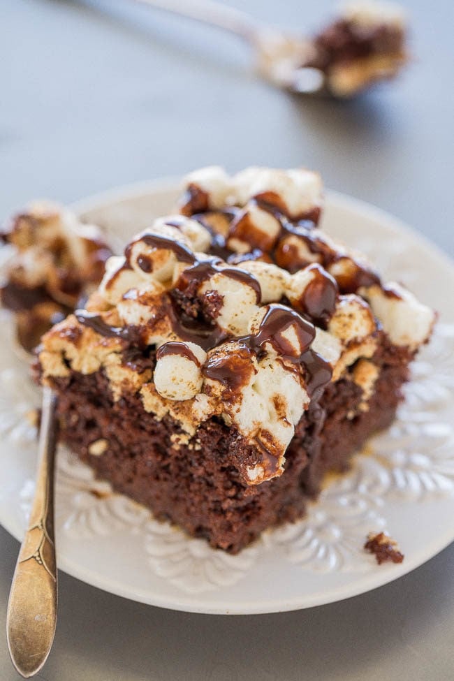 Smores Poke Cake - A supremely moist and decadent chocolate cake topped with graham crackers, marshmallows, and hot fudge!! Campfire not required for this FUN and EASY twist on smores!!