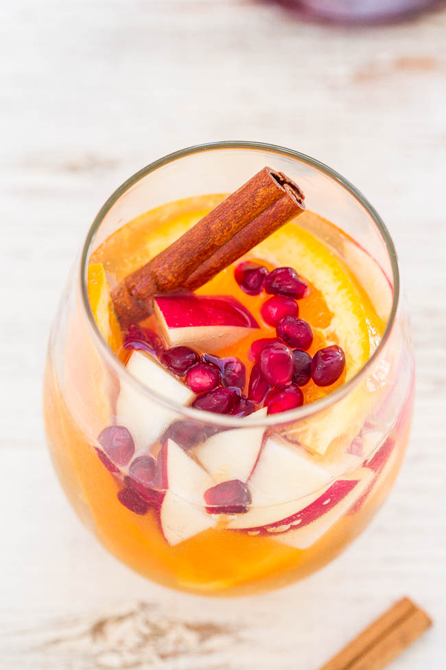 glass of apple sangria garnished with a cinnamon stick and fruit 