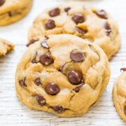 Homemade chocolate chip cookies on a wooden surface.