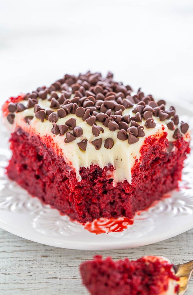 Red Velvet Poke Cake with Cream Cheese Frosting on a white plate 