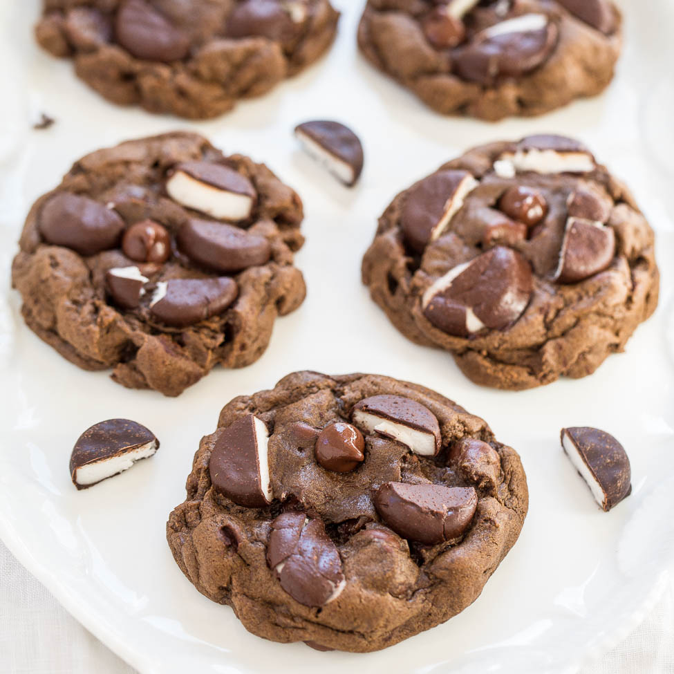 Freshly baked chocolate cookies with chocolate chunks on a white plate.