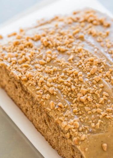 A rectangular coffee cake topped with a glaze and crushed nuts.
